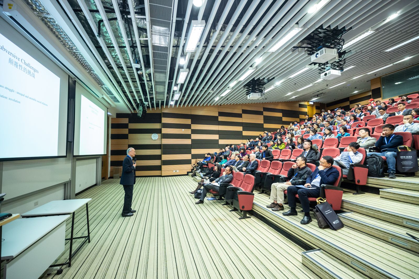 Speaker addressing a seated audience at a corporate conference managed by Tingle Works