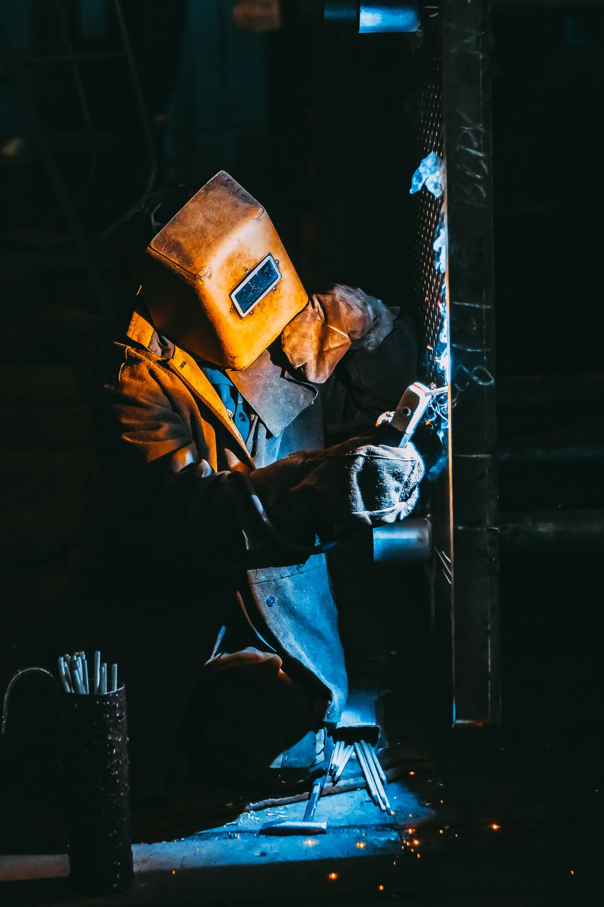 Production & Fabrication Worker welding metal with sparks flying in a fabrication workshop